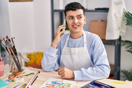 Photo for Young non binary man artist smiling confident talking on the smartphone at art studio - Royalty Free Image