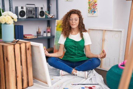 Téléchargez les photos : Young beautiful hispanic woman artist smiling confident doing yoga exercise at art studio - en image libre de droit