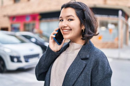 Photo for Young woman smiling confident talking on the smartphone at street - Royalty Free Image