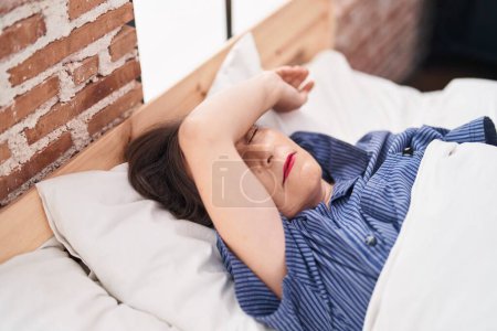 Téléchargez les photos : Middle age woman stressed lying on bed at bedroom - en image libre de droit