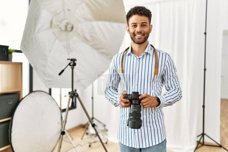 Photo for Young arab photographer man smiling happy using reflex camera at photo studio. - Royalty Free Image