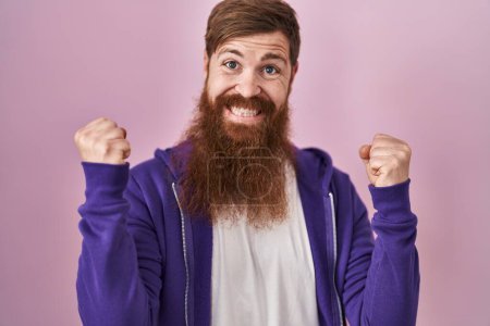 Photo for Caucasian man with long beard standing over pink background celebrating surprised and amazed for success with arms raised and open eyes. winner concept. - Royalty Free Image