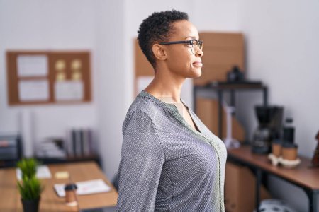 Téléchargez les photos : African american woman working at the office wearing glasses looking to side, relax profile pose with natural face with confident smile. - en image libre de droit