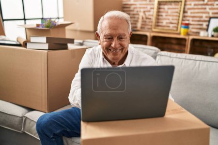 Photo for Senior man smiling confident using laptop at new home - Royalty Free Image