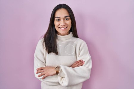 Téléchargez les photos : Young south asian woman standing over pink background happy face smiling with crossed arms looking at the camera. positive person. - en image libre de droit