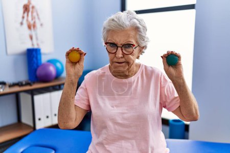 Photo for Senior woman with grey hair holding hands strength balls skeptic and nervous, frowning upset because of problem. negative person. - Royalty Free Image