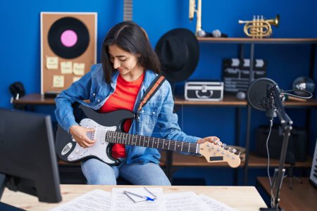 Téléchargez les photos : Young hispanic girl artist playing electrical guitar at music studio - en image libre de droit