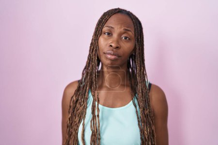 Photo for African american woman standing over pink background looking sleepy and tired, exhausted for fatigue and hangover, lazy eyes in the morning. - Royalty Free Image