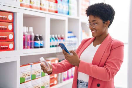Foto de Cliente afroamericano mujer hacer foto a la botella de medicación en la farmacia - Imagen libre de derechos