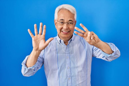 Photo for Hispanic senior man wearing glasses showing and pointing up with fingers number eight while smiling confident and happy. - Royalty Free Image