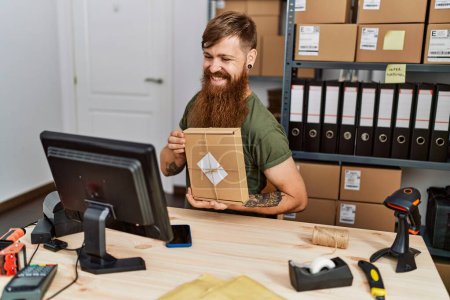 Téléchargez les photos : Young redhead man business worker having video call holding package at office - en image libre de droit
