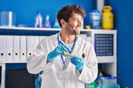 Photo for Young man scientist smiling confident writing on test tube at laboratory - Royalty Free Image
