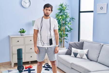Photo for Handsome latin man wearing sportswear at home depressed and worry for distress, crying angry and afraid. sad expression. - Royalty Free Image