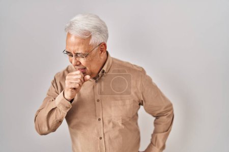 Téléchargez les photos : Un aîné hispanique portant des lunettes se sent mal et tousse comme symptôme du rhume ou de la bronchite. concept de soins de santé. - en image libre de droit