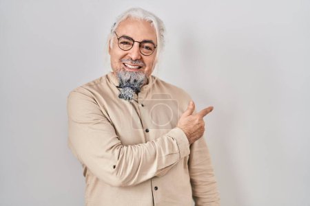 Photo for Middle age man with grey hair standing over isolated background with a big smile on face, pointing with hand and finger to the side looking at the camera. - Royalty Free Image