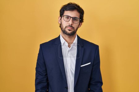 Photo for Handsome latin man standing over yellow background looking sleepy and tired, exhausted for fatigue and hangover, lazy eyes in the morning. - Royalty Free Image