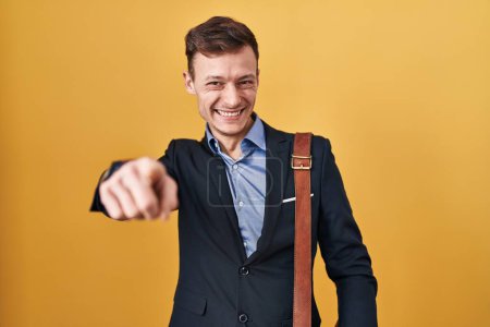 Foto de Caucásico hombre de negocios sobre fondo amarillo que apunta a usted y la cámara con los dedos, sonriendo positivo y alegre - Imagen libre de derechos