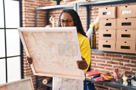 Téléchargez les photos : African woman looking at painter canvas angry and mad screaming frustrated and furious, shouting with anger. rage and aggressive concept. - en image libre de droit