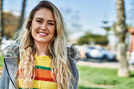 Téléchargez les photos : Jeune femme blonde souriant au parc - en image libre de droit