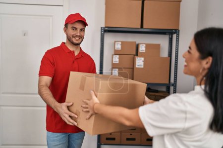 Photo for Man and woman deliveryman and worker holding package at storehouse - Royalty Free Image