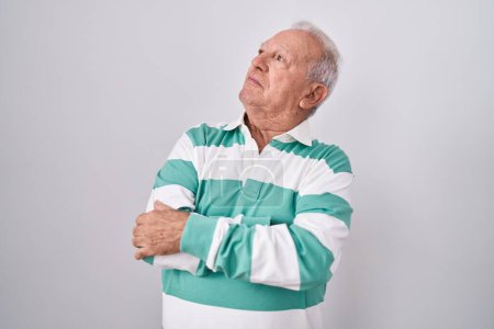 Téléchargez les photos : Senior man with grey hair standing over white background looking to the side with arms crossed convinced and confident - en image libre de droit