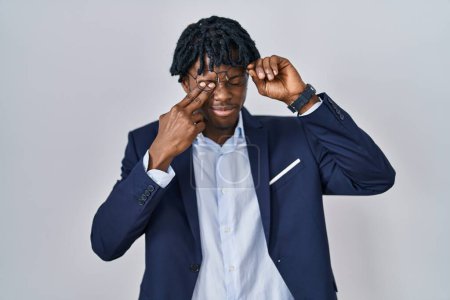 Téléchargez les photos : Jeune homme africain avec dreadlocks veste d'affaires sur fond blanc frottant les yeux pour la fatigue et les maux de tête, somnolent et l'expression fatiguée. problème de vision - en image libre de droit
