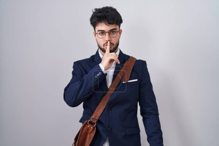 Photo for Hispanic man with beard wearing business clothes asking to be quiet with finger on lips. silence and secret concept. - Royalty Free Image