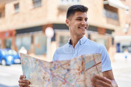 Photo for Young hispanic man smiling confident holding city map at street - Royalty Free Image