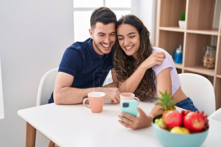 Photo for Young hispanic couple drinking coffee having video call at home - Royalty Free Image