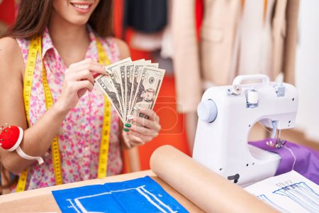Photo for Young beautiful hispanic woman tailor smiling confident counting dollars at atelier - Royalty Free Image