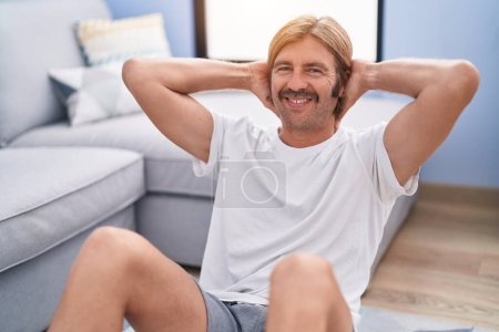 Téléchargez les photos : Young blond man smiling confident training abs exercise at home - en image libre de droit