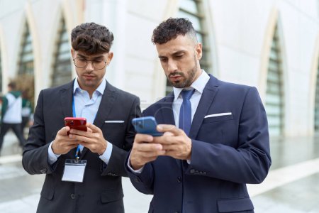Photo for Two hispanic men business workers using smartphones at street - Royalty Free Image