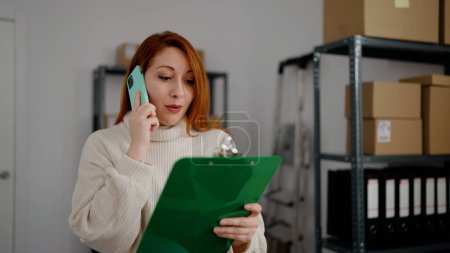 Photo for Young redhead woman ecommerce business worker talking on the smartphone at office - Royalty Free Image