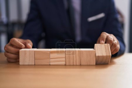 Photo for Young latin man business worker sitting on table with wooden cubes at office - Royalty Free Image