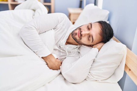 Photo for Young hispanic man lying on bed sleeping at bedroom - Royalty Free Image
