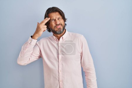 Téléchargez les photos : Handsome middle age man wearing elegant shirt background shooting and killing oneself pointing hand and fingers to head like gun, suicide gesture. - en image libre de droit