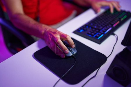 Foto de Middle age man using computer keyboard and mouse at gaming room - Imagen libre de derechos