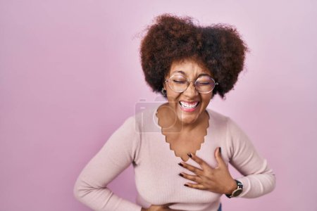 Photo for Young african american woman standing over pink background smiling and laughing hard out loud because funny crazy joke with hands on body. - Royalty Free Image