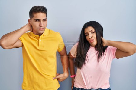 Photo for Young couple standing over isolated background suffering of neck ache injury, touching neck with hand, muscular pain - Royalty Free Image