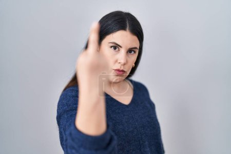 Photo for Young brunette woman standing over isolated background showing middle finger, impolite and rude fuck off expression - Royalty Free Image
