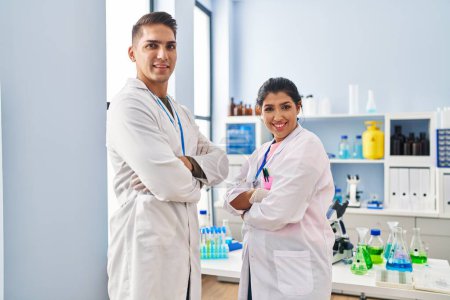 Photo for Man and woman scientists partners standing with arms crossed gesture at laboratory - Royalty Free Image