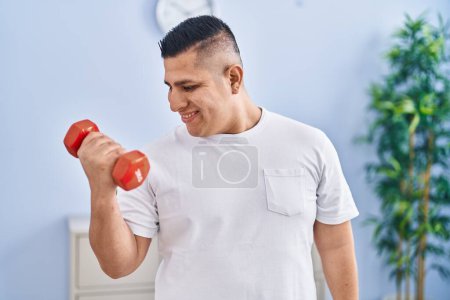 Téléchargez les photos : Young latin man smiling confident using dumbbell training at home - en image libre de droit