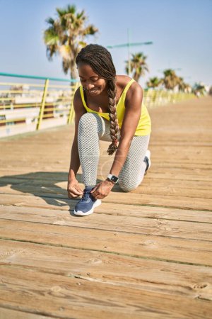Photo for African american woman smiling confident tying shoe at street - Royalty Free Image