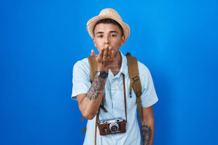 Photo for Brazilian young man holding vintage camera looking at the camera blowing a kiss with hand on air being lovely and sexy. love expression. - Royalty Free Image