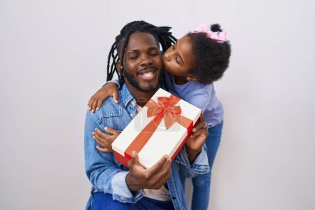 Foto de Father and daughter surprise with gift hugging each other over isolated white background - Imagen libre de derechos