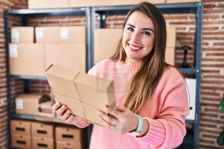 Photo for Young beautiful hispanic woman ecommerce business worker holding package at office - Royalty Free Image