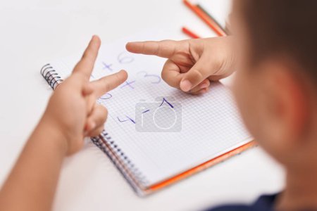 Téléchargez les photos : Adorable bambin hispanique faisant des exercices mathématiques compter avec les doigts en classe - en image libre de droit