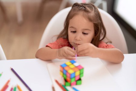 Téléchargez les photos : Adorable hispanic girl playing with toys sitting on table at kindergarten - en image libre de droit