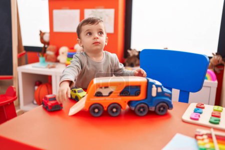 Téléchargez les photos : Adorable hispanic boy playing with truck an cars toy at kindergarten - en image libre de droit