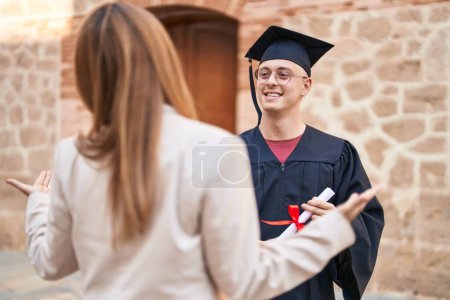 Photo for Man and woman mother and son standing together holding graduate diploma at university - Royalty Free Image